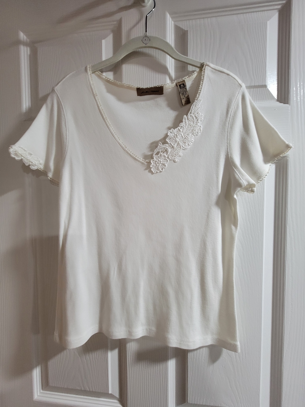 Cute white V-neck top. Has pretty lace trim around the neckline-size M